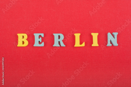 BERLIN word on red background composed from colorful abc alphabet block wooden letters, copy space for ad text. Learning english concept.