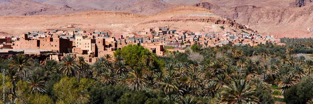 Moroccan kasbah. A village by an oasis with palm trees. Atlas Mountains, Morocco