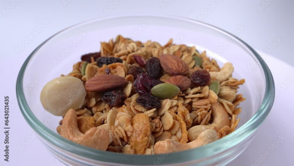 Corn flakes with nuts on white background. Rotating cereal. Healthy breakfast. 4k video Corn flakes with nuts on white background. Rotating cereal. Healthy breakfast. 4k video