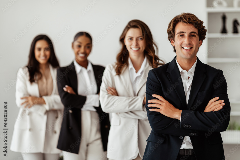 Male leadership concept. Diverse business team standing in line with folded arms and smiling at camera posing in office Male leadership concept. Diverse business team standing in line with folded arms and smiling at camera posing in office