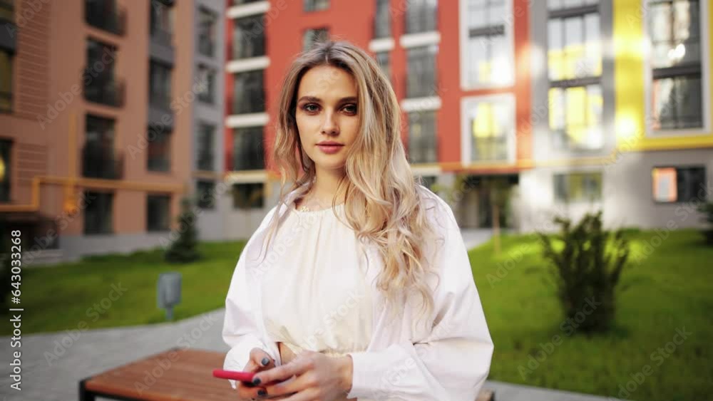 Portrait of confident carefree young blond woman enjoying great day and looking at the camera at city street Beautiful female outdoors alone Portrait of confident carefree young blond woman enjoying great day and looking at the camera at city street Beautiful female outdoors alone