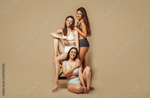 Cheerful calm young arabic, latin and european women in different underwear enjoy natural beauty, body type photo