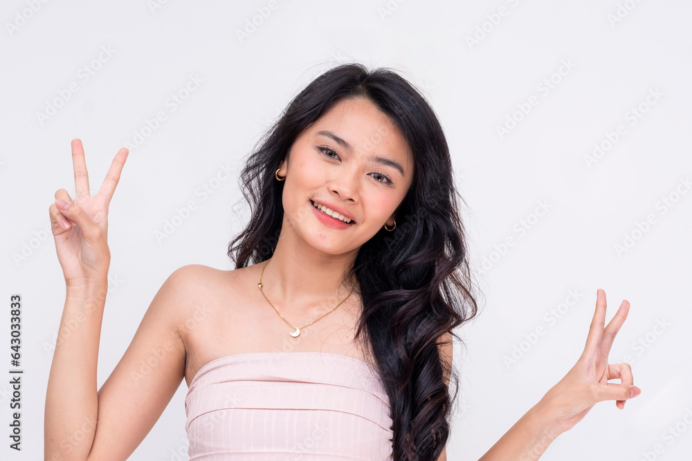 Headshot of a cute and beautiful asian teenage woman making double peace signs. Isolated on a white backdrop Headshot of a cute and beautiful asian teenage woman making double peace signs. Isolated on a white backdrop