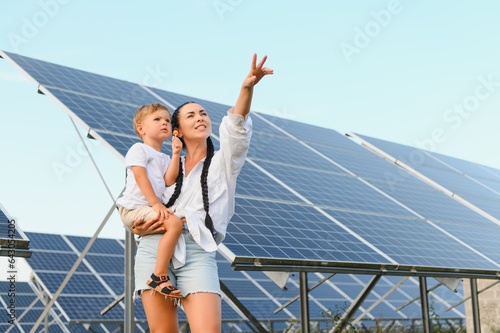 Mother with her little son by solar panels