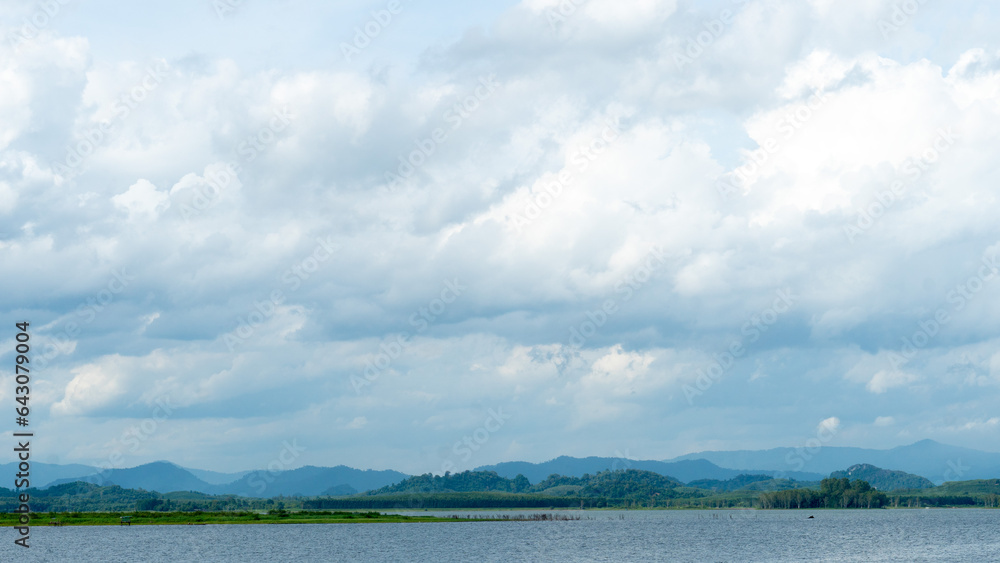 Horizontal view of river or reservoir 
of Prasae Wang Chan of Rayong. Background of mountain far the way. Under the sky and white clouds.