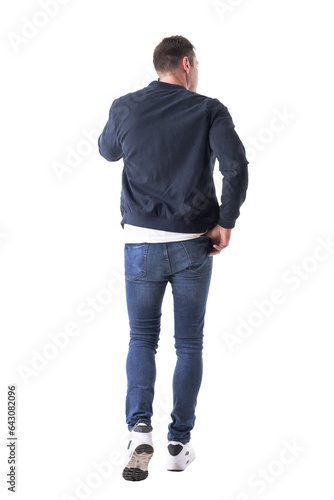 Cool relaxed man with hand in back pocket walking and talking on the phone looking away. Full body isolated on transparent background.