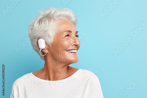 Mature woman listening to sound in her new hearing aid. She is happy because the sound test is good and she hears