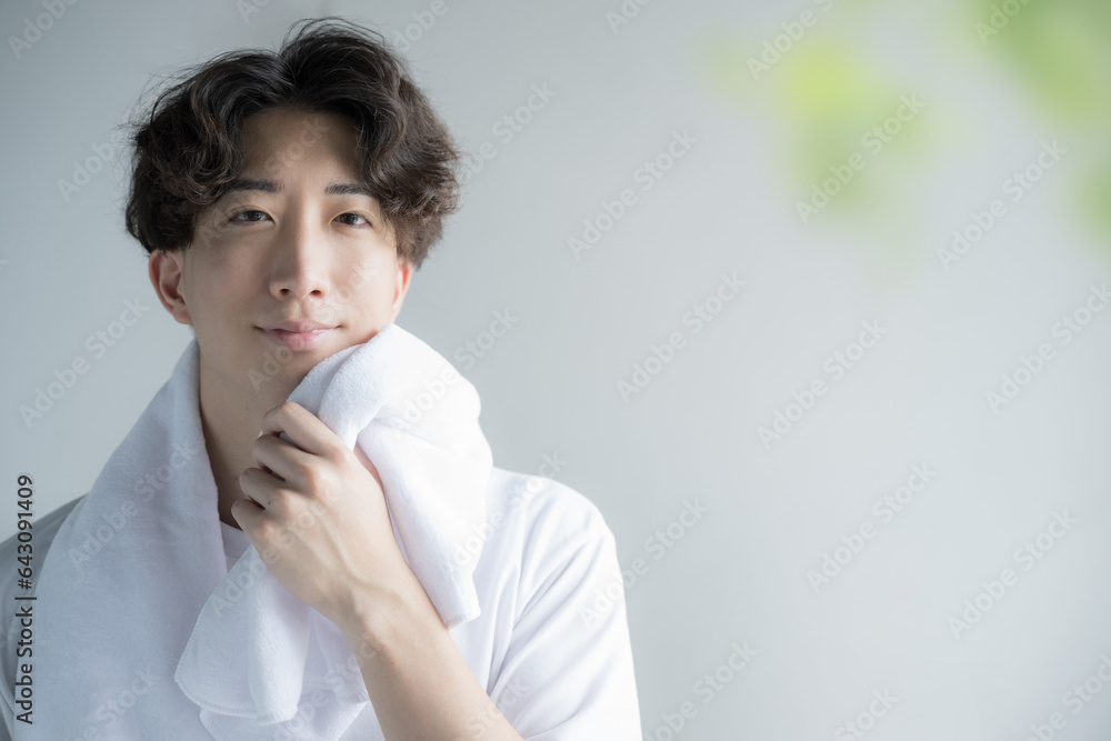 Handsome camera-ready man wiping his face with a towel Image of training and face washing Handsome camera-ready man wiping his face with a towel Image of training and face washing