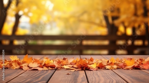 Beautiful colorful natural autumn background. Fallen dry orange leaves on wooden boards against the backdrop of a blurry autumn park.