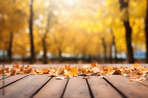 Beautiful colorful natural autumn background. Fallen dry orange leaves on wooden boards against the backdrop of a blurry autumn park.