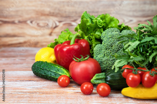 Fresh vegetables, fruits and greens on a wooden background. Healthy food, harvesting, farming. Copy space.