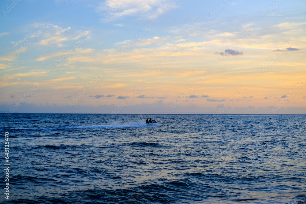 Naklejka premium ride a jet ski on the beach, sunset over the sea, sunset in the sea, sea and sky, sunset over sea, beautiful sunset sky, blue and orange sky, sunset wallpaper