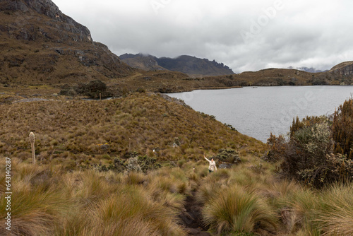 mujer senderista levantando los brazos en el camino de garcia moreno en el parque nacional cajas en cuenca azuay ecuador photo