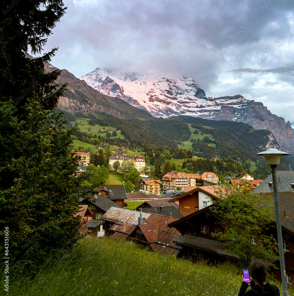 Snow Covered Mountain at Sunset in The Swiss Alps in Switzerland in Summer with Buildings Sitting Along the Hills