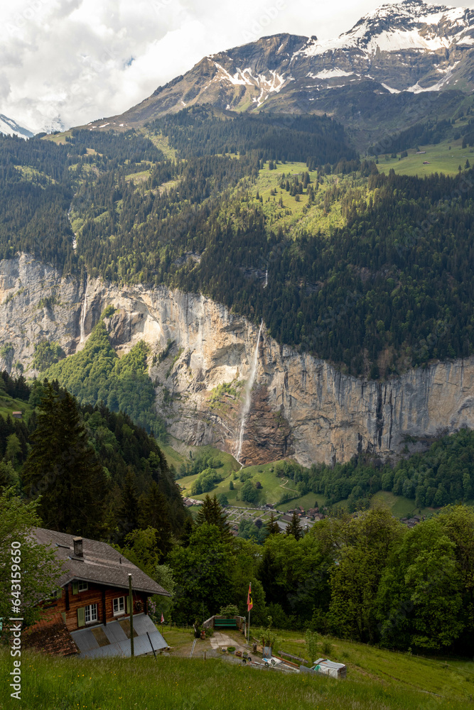 Waterrfall in the Swiss Alps in Switzerland in the Summer With Mountains Peaking Through the Clouds in the Background Waterrfall in the Swiss Alps in Switzerland in the Summer With Mountains Peaking Through the Clouds in the Background