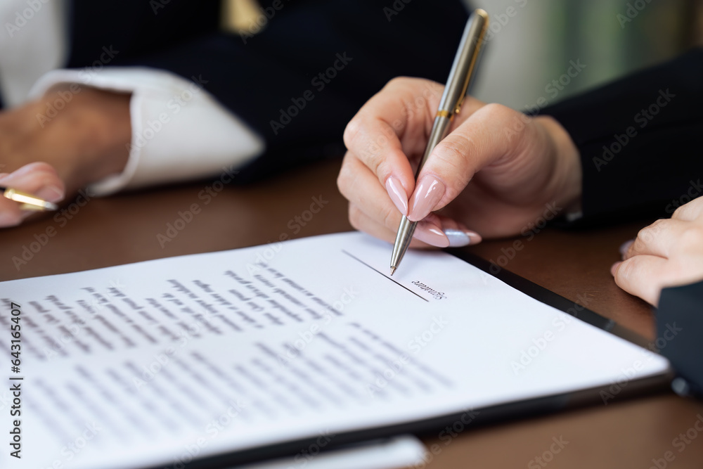 Close up businessperson or lawyer signing his signature to agreement document Close up businessperson or lawyer signing his signature to agreement document