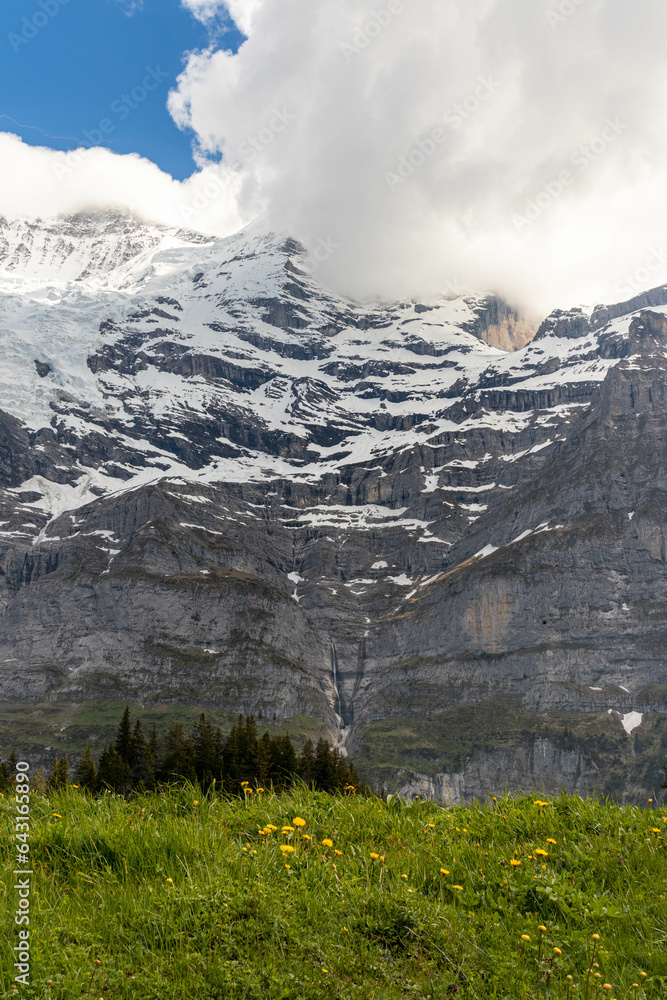 Fototapeta premium Close Up of a Mountain in the Swiss Alps in Switzerland in the Summer with Mountains Peaking Through Clouds in the Background
