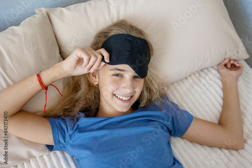 portrait of a teenage girl in a sleep mask. Happy smile and good mood.