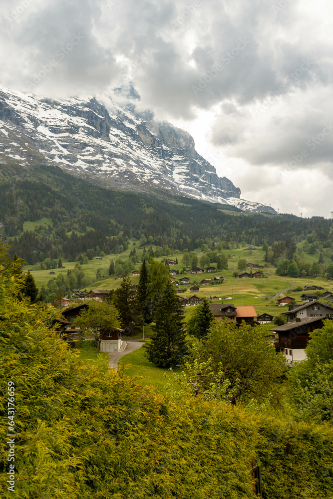 Buildings Sitting Along the Hills high up in the Swiss Alps with mountains in the background in Switzerland in Summer