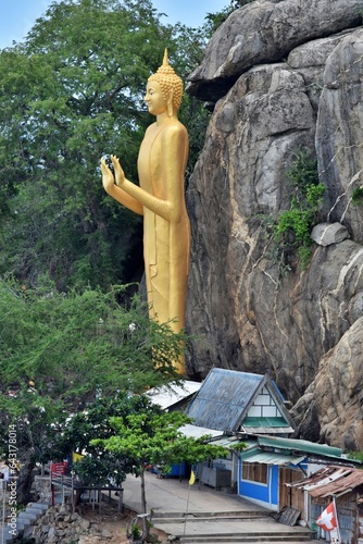 Golden Standing Buddha statue, the landmark of Hua Hin, standing tall at Khao Takiab temple on Hua Hin beach, Thailand.