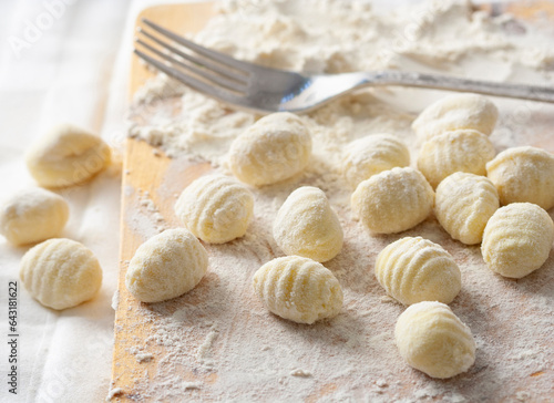 Freshly made flour and potato gnocchi, on a wooden board.