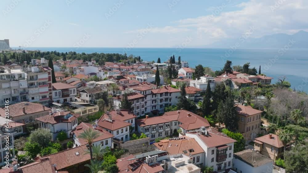 Forwards fly above houses in old town. Traditional houses in urban borough at sea side. Antalya, Turkey Forwards fly above houses in old town. Traditional houses in urban borough at sea side. Antalya, Turkey