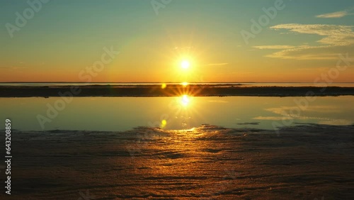 Fantastic unearthly look sunset with the reflection of two suns on the surface of the water photo