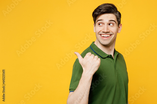 Quadro su tela Young smiling happy man wears green t-shirt casual clothes point thumb finger as
