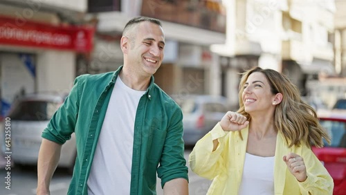 Man and woman couple smiling confident standing together dancing at street