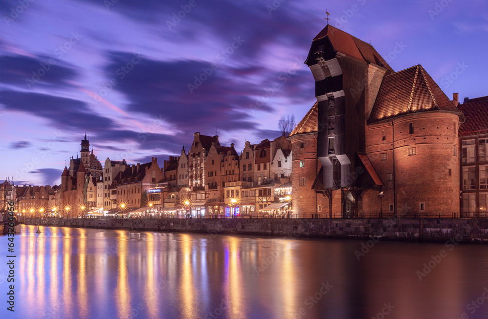 Old harbour crane and city gate Zuraw in old town of Gdansk at night, Poland