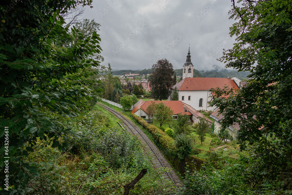 Train track leading between stations of Kamnik Mesto and Kamnik graben, looking towards north observing churches and thick clouds. Train track leading between stations of Kamnik Mesto and Kamnik graben, looking towards north observing churches and thick clouds.