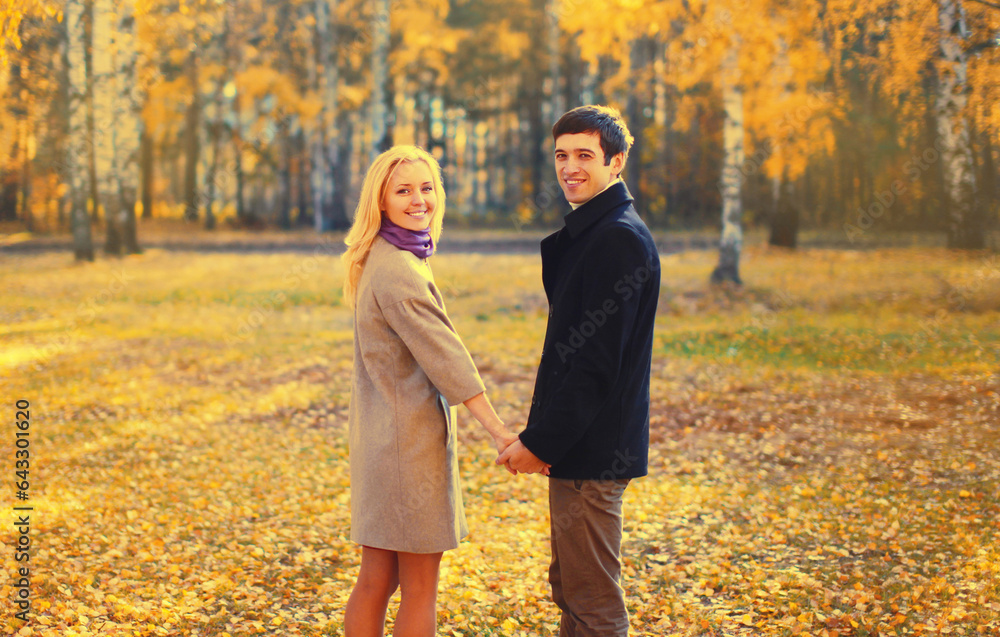 Portrait of happy loving young couple together in autumn park on warm sunny day Portrait of happy loving young couple together in autumn park on warm sunny day