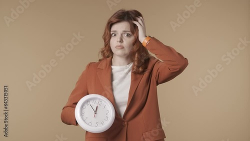 Medium isolated video of a shocked and worried young woman looking at the clock and shaking her head. HDR BT2020 HLG Material. photo
