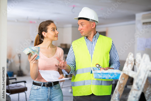 Принти на полотні Man builder receiving money from woman employer, construction manager