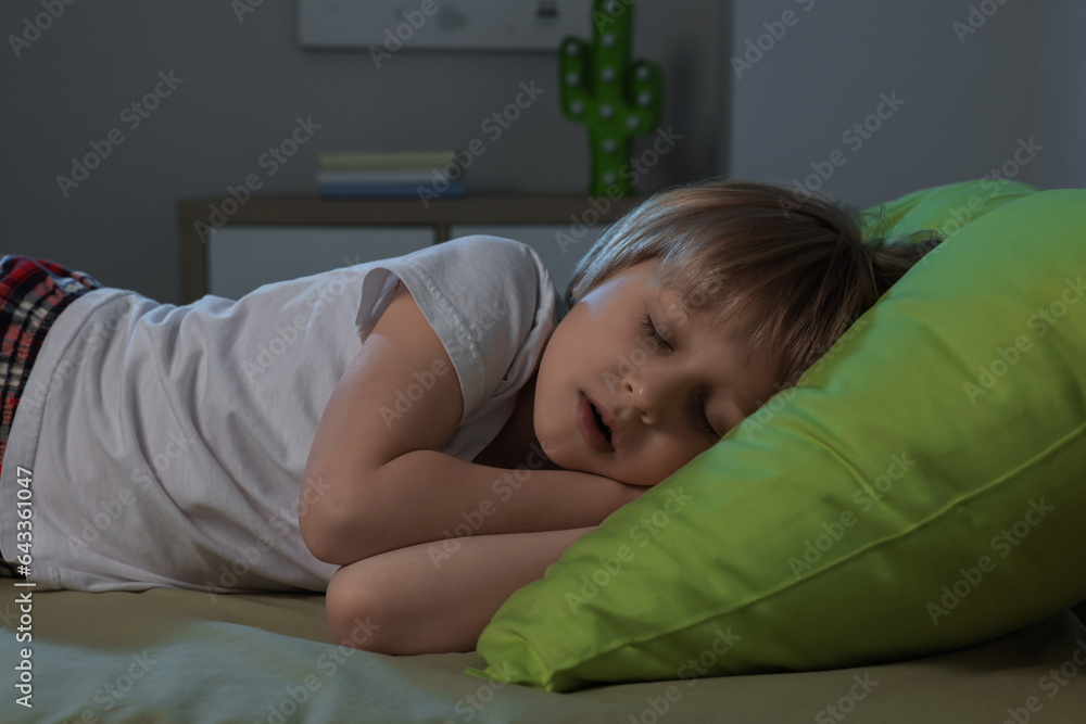 Fototapeta premium Little boy snoring while sleeping on bed at night