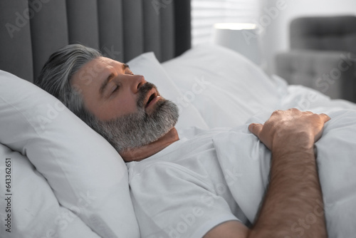 Tableau sur toile Man snoring while sleeping in bed at home