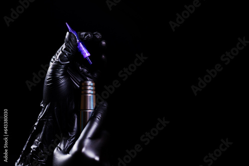 Girl in black latex gloves holds a permanent makeup machine and a cartridge for it.  Tattoo machine.  Cosmetic procedures.  Isolated on white background