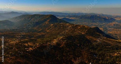 Lonely houses scattered along the mountains among the pine trees. Beautiful panorama of Sierra National Forest, California, USA. Aerial view. photo
