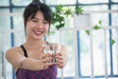 Woman drinking water hands holding cold mineral water cool drinking. Asian women smile laugh look away health care home fitness lifestyle. Cheerful Beautiful female drink glass of water smile face