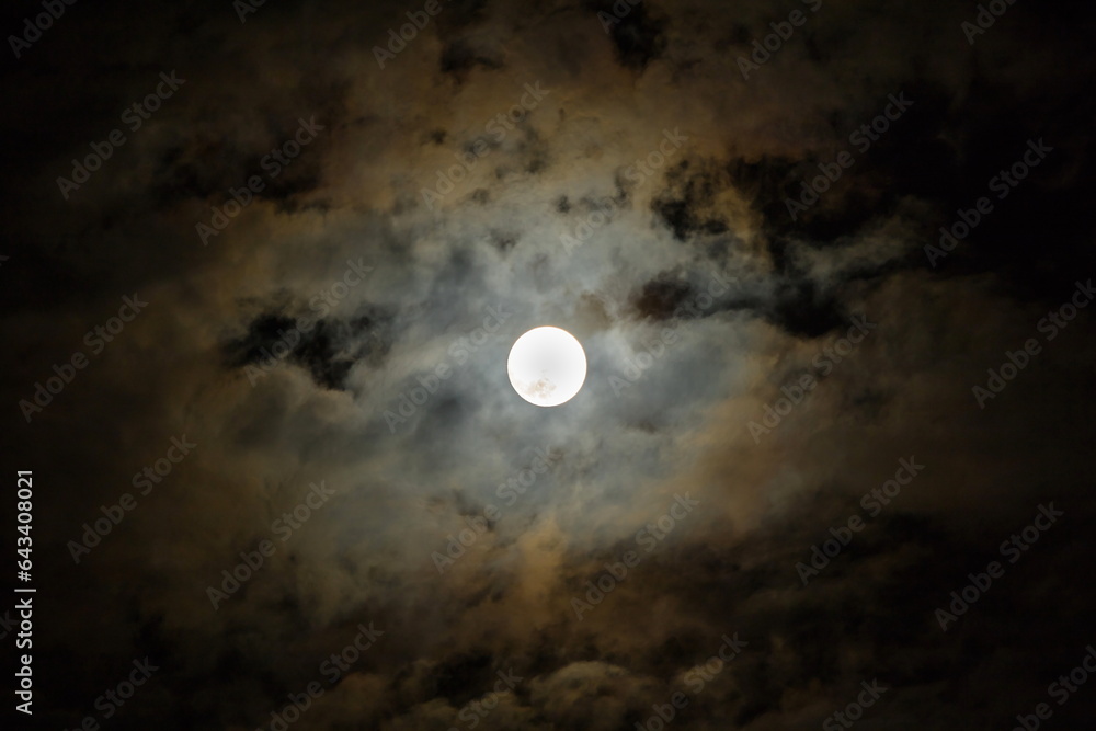 Full moon in the dark night sky with clouds. Halloween background,dark clouds, closeup.
