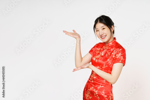 Happy Chinese new year. Asian woman wearing traditional cheongsam qipao dress with gesture of introduce isolated on white background. photo
