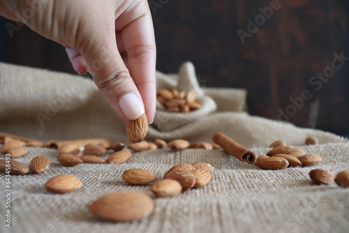 taking an almond from the table with his hand