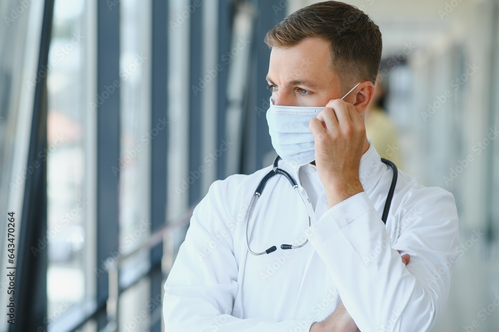 Sad doctor standing in hospital corridor Sad doctor standing in hospital corridor