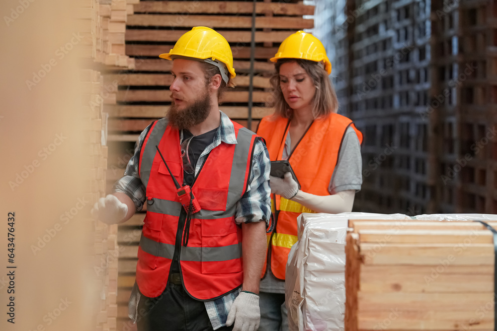 Warehouse worker working at lumber yard in Large Warehouse. Worker are Inventory check at Storage shelves in lumberyard. Warehouse worker working at lumber yard in Large Warehouse. Worker are Inventory check at Storage shelves in lumberyard.