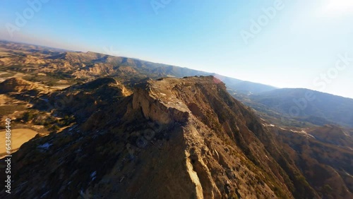 FPV aerial drone flying fast along the ridge of a rock formation in the Monegros Desert, Spain. photo