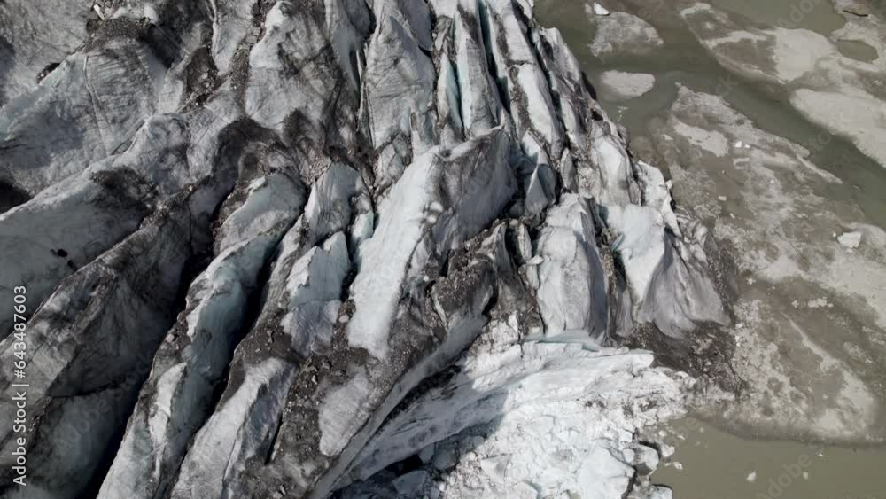 Drone shot revealing Pasterze Glacier and streams of water pouring down the valley walls into the glacier lake in the background Drone shot revealing Pasterze Glacier and streams of water pouring down the valley walls into the glacier lake in the background