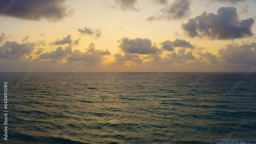 Aerial drone shot slowly rising above the beach near Palm Beach, Florida as the waves crash and the sunrise begins to peek through the clouds. Aerial drone shot slowly rising above the beach near Palm Beach, Florida as the waves crash and the sunrise begins to peek through the clouds.