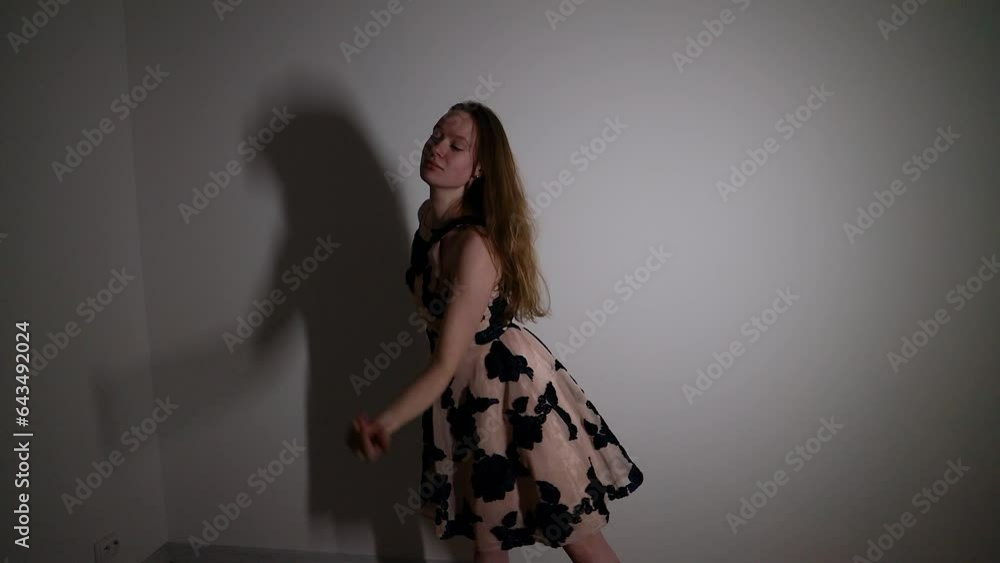 Young female dancer performing a dance in a small dark room Young female dancer performing a dance in a small dark room