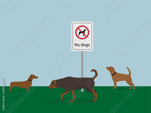Three dogs are walking on the grass next to a "No dogs" sign