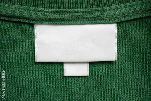 Photography Blank white laundry care clothes label on green shirt fabric texture background